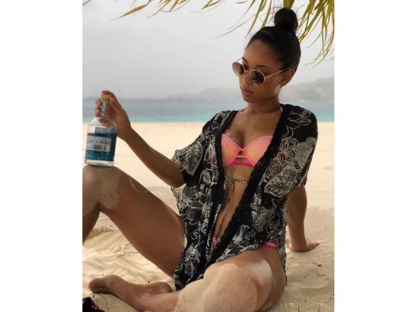 girl sitting on beach with a bottle